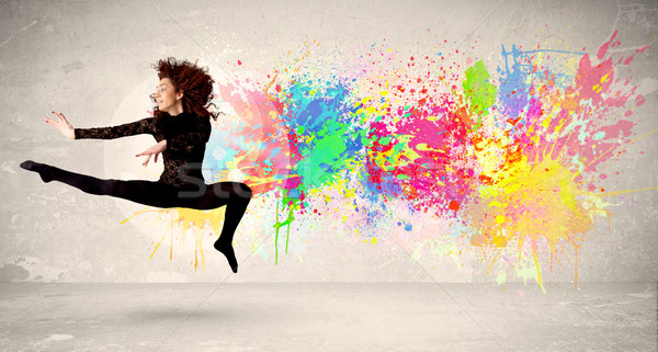 Happy teenager jumping with colorful ink splatter on urban backg Stock photo © ra2studio