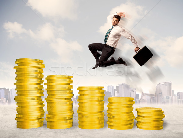 Bem sucedido homem de negócios saltando para cima moeda de ouro dinheiro Foto stock © ra2studio
