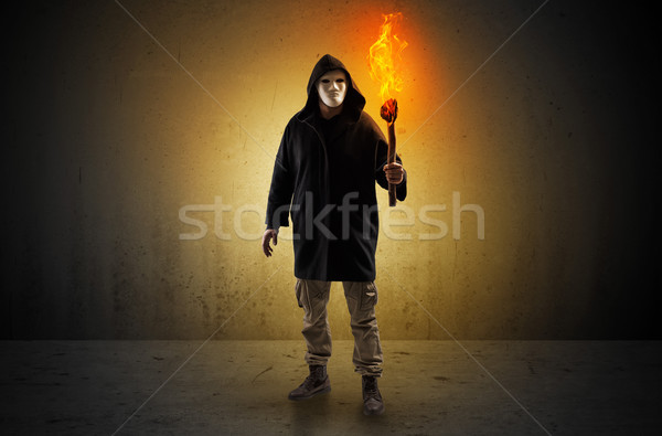 Man walking in an empty space with burning flambeau Stock photo © ra2studio