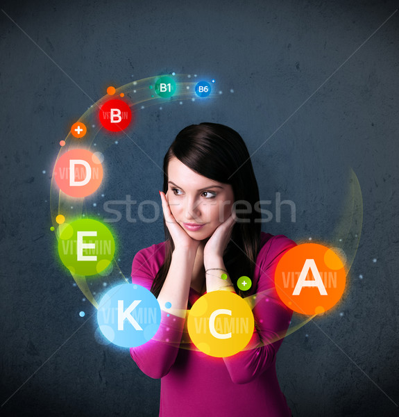 Young woman thinking with vitamins circulation around her head Stock photo © ra2studio