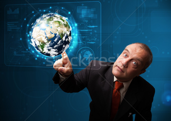 Businessman touching high-tech 3d earth panel Stock photo © ra2studio