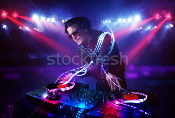Disc jockey playing music with light beam effects on stage Stock photo © ra2studio