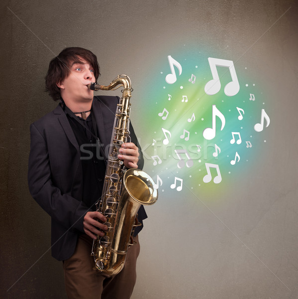 Foto stock: Jóvenes · músico · jugando · saxófono · notas · musicales · atractivo