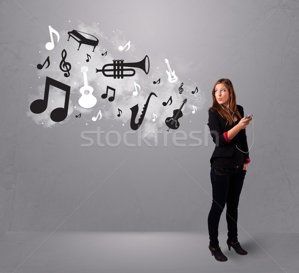 Foto stock: Hermosa · cantando · escuchar · música · notas · musicales · fuera