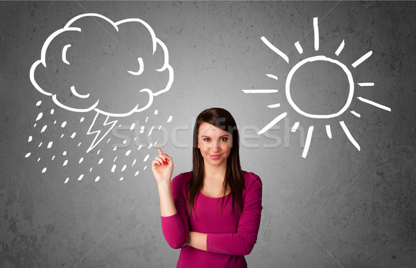 Stock photo: Woman standing between a sun and a rain drawing