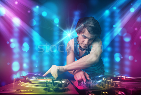 Dj mixing music in a club with blue and purple lights Stock photo © ra2studio