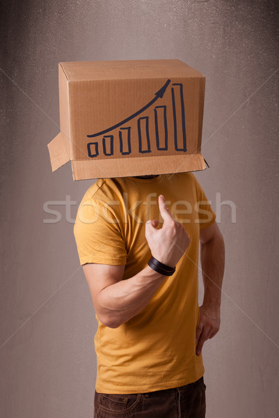 Young man gesturing with a cardboard box on his head with diagra Stock photo © ra2studio