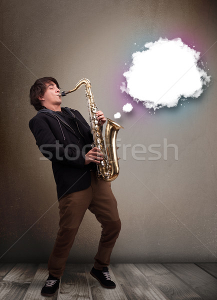 Young man playing on saxophone with copy space in white cloud Stock photo © ra2studio