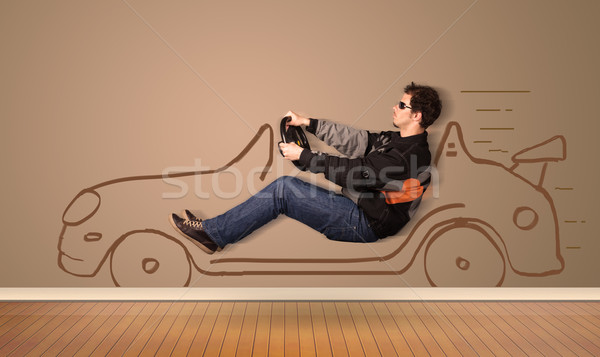 Happy man driving an hand drawn car on the wall Stock photo © ra2studio