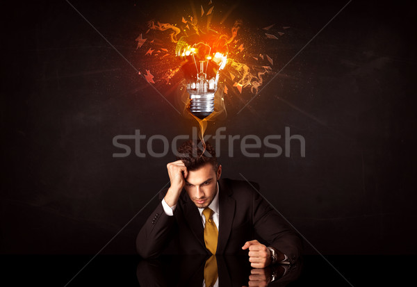 Businessman sitting under a blowing idea bulb Stock photo © ra2studio