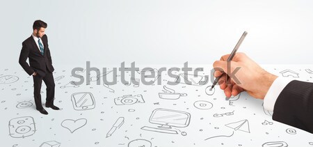 Little businessman looking at hand drawn icons and symbols Stock photo © ra2studio