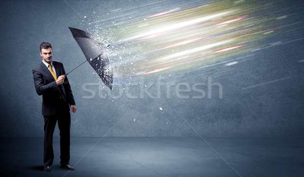 Business man defending light beams with umbrella concept Stock photo © ra2studio