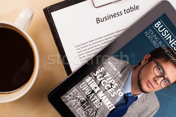 Workplace with tablet pc showing magazine cover and a cup of coffee on a wooden work table closeup Stock photo © ra2studio