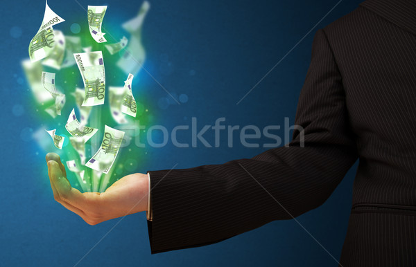 Stock photo: Glowing money in the hand of a businessman