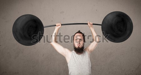 Funny skinny guy lifting weights Stock photo © ra2studio