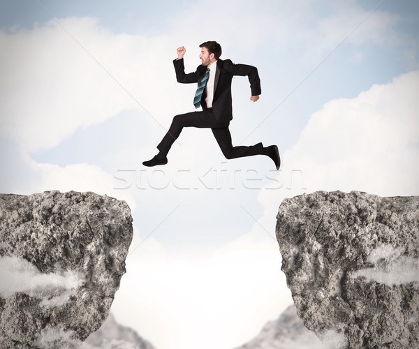 Funny człowiek biznesu skoki skał luka działalności Zdjęcia stock © ra2studio