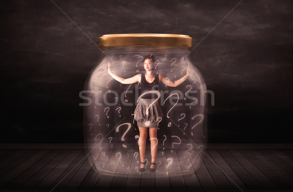 Businesswoman locked into a jar with question marks concept Stock photo © ra2studio