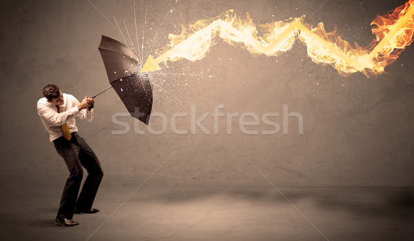 Business man defending himself from a fire arrow with an umbrell Stock photo © ra2studio