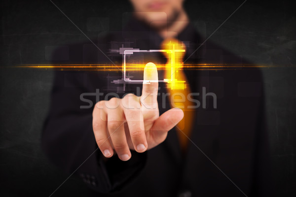 Tech business person touching button with orange light beams con Stock photo © ra2studio