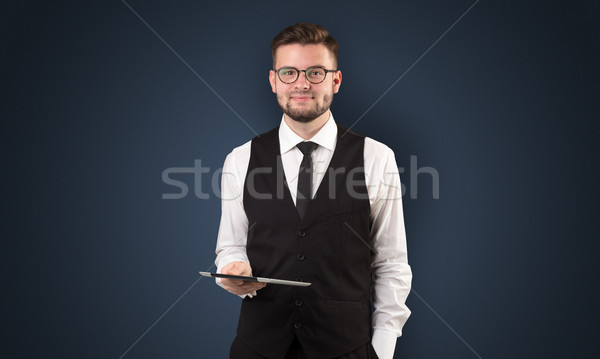 Businessman holding tablet with dark background Stock photo © ra2studio