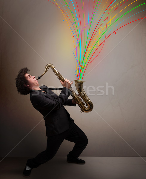 Attractive musician playing on saxophone while colorful abstract Stock photo © ra2studio