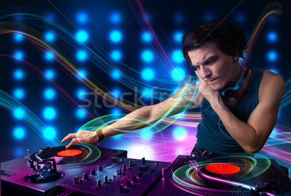 Young Dj mixing records with colorful lights Stock photo © ra2studio