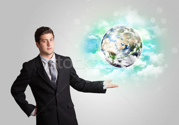 Young man with earth and cloud concept Stock photo © ra2studio