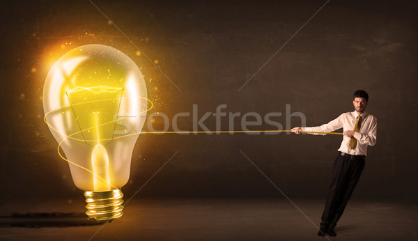 üzletember húz nagy fényes izzó villanykörte Stock fotó © ra2studio