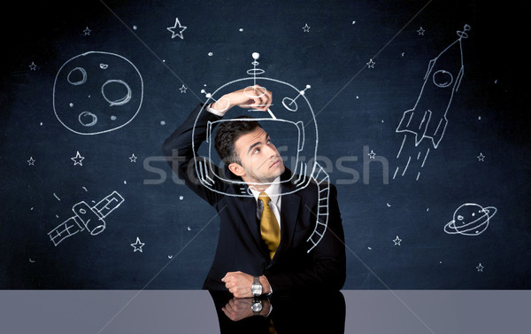 Sales person drawing helmet and space rocket Stock photo © ra2studio