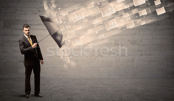 Business man protecting with umbrella against wind of papers Stock photo © ra2studio