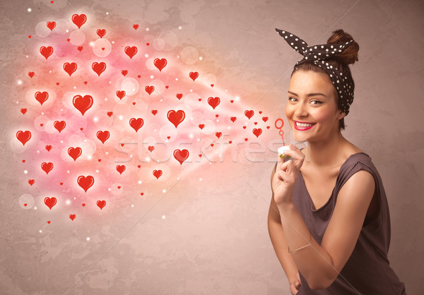 Pretty young girl blowing red heart symbols  Stock photo © ra2studio