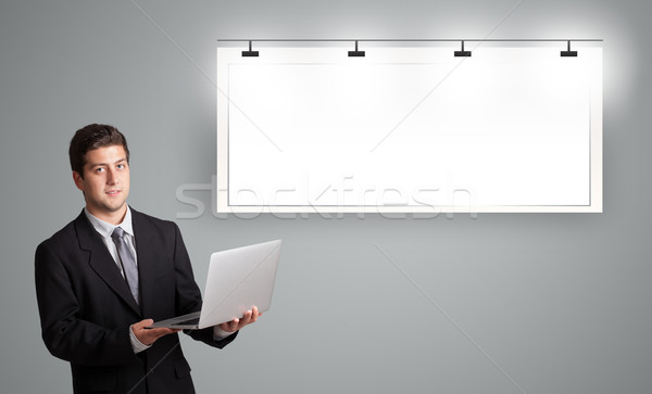 handsome young man standing next to a modern copy space and holding laptop Stock photo © ra2studio