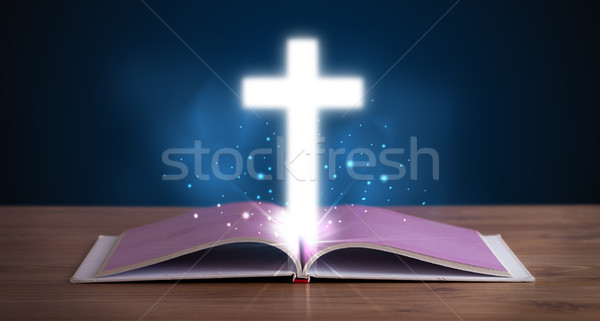 Open holy bible with glowing cross in the middle Stock photo © ra2studio