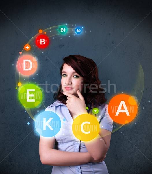 Young woman thinking with vitamins circulation around her head Stock photo © ra2studio