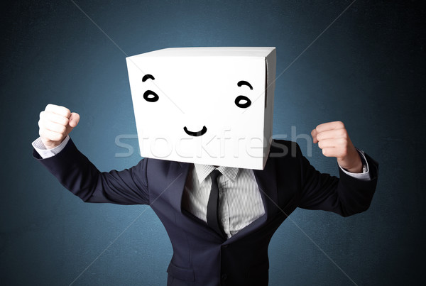 Businessman gesturing with a cardboard box on his head with smil Stock photo © ra2studio