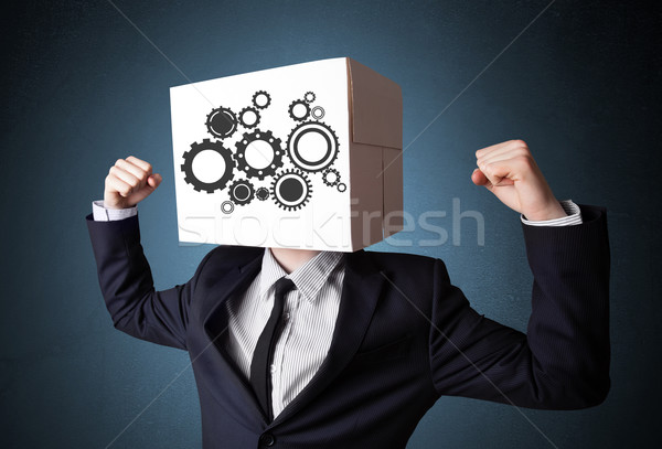 Businessman gesturing with a cardboard box on his head with spur Stock photo © ra2studio