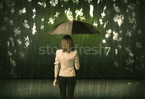 Stock photo: Businesswoman standing with umbrella and 3d numbers raining conc