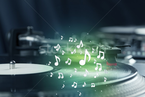 Turntable playing music with audio notes glowing Stock photo © ra2studio