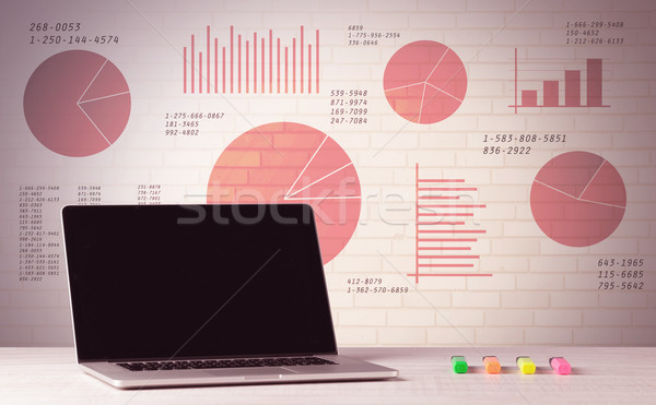 Laptop on office desk with sales pie charts Stock photo © ra2studio