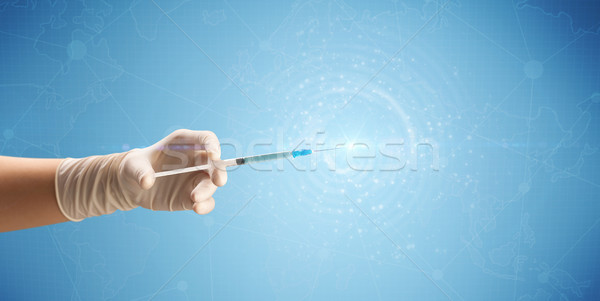 Homme médecin seringue main bleu [[stock_photo]] © ra2studio