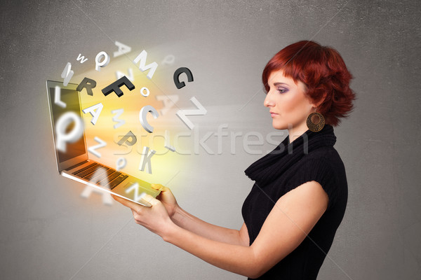 Young lady hoolding notebook with colorful abstract letters Stock photo © ra2studio