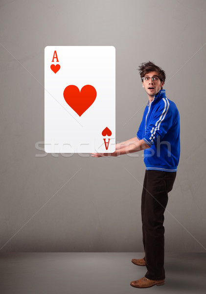 Young man holding a red heart ace Stock photo © ra2studio