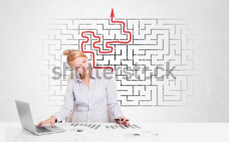 Business woman at desk with labyrinth and arrow Stock photo © ra2studio