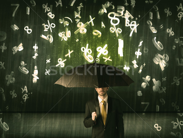 Businessman standing with umbrella and 3d numbers raining concep Stock photo © ra2studio