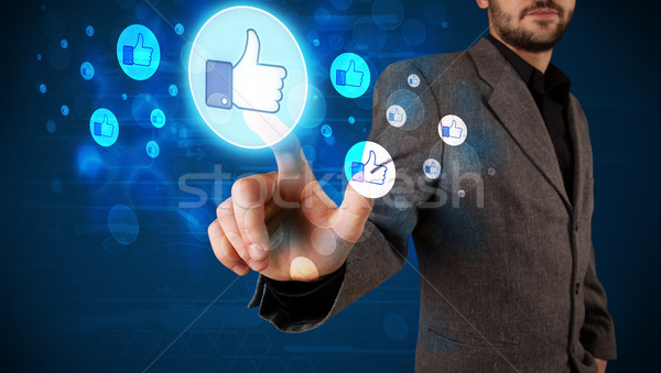 Handsome person pressing thumbs up button on modern social netwo Stock photo © ra2studio