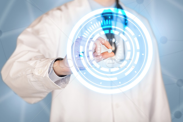 Male doctor holding a pill with glowing circles Stock photo © ra2studio