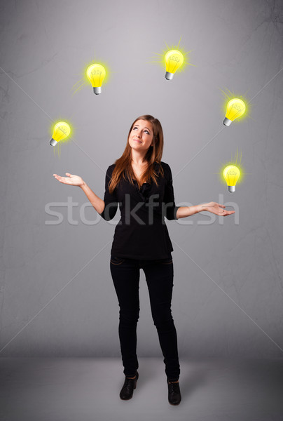 young lady standing and juggling with light bulbs Stock photo © ra2studio