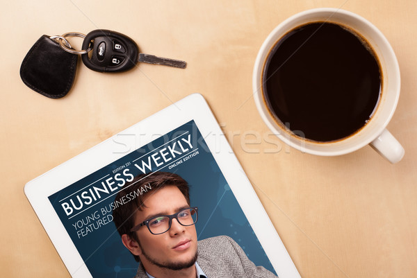 Workplace with tablet pc showing magazine cover and a cup of coffee on a wooden work table closeup Stock photo © ra2studio