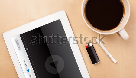 Workplace with tablet pc showing media player and a cup of coffee on a wooden work table closeup Stock photo © ra2studio