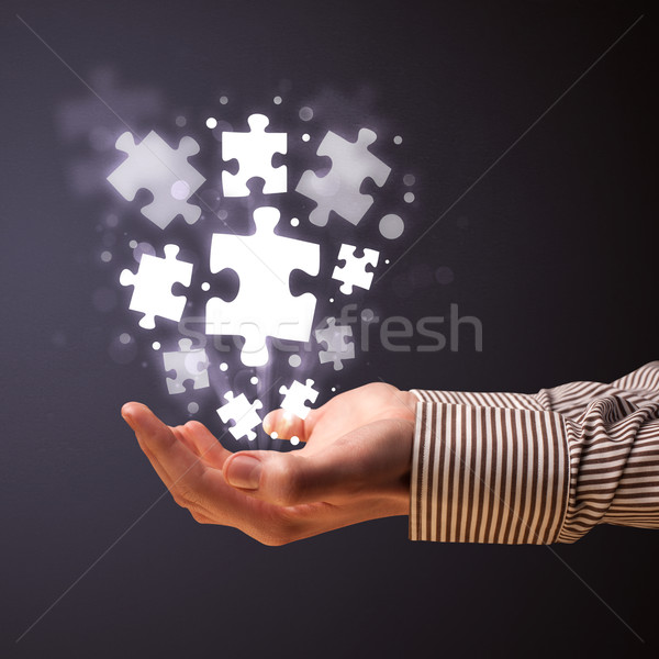 Puzzle pieces in the hand of a businessman Stock photo © ra2studio